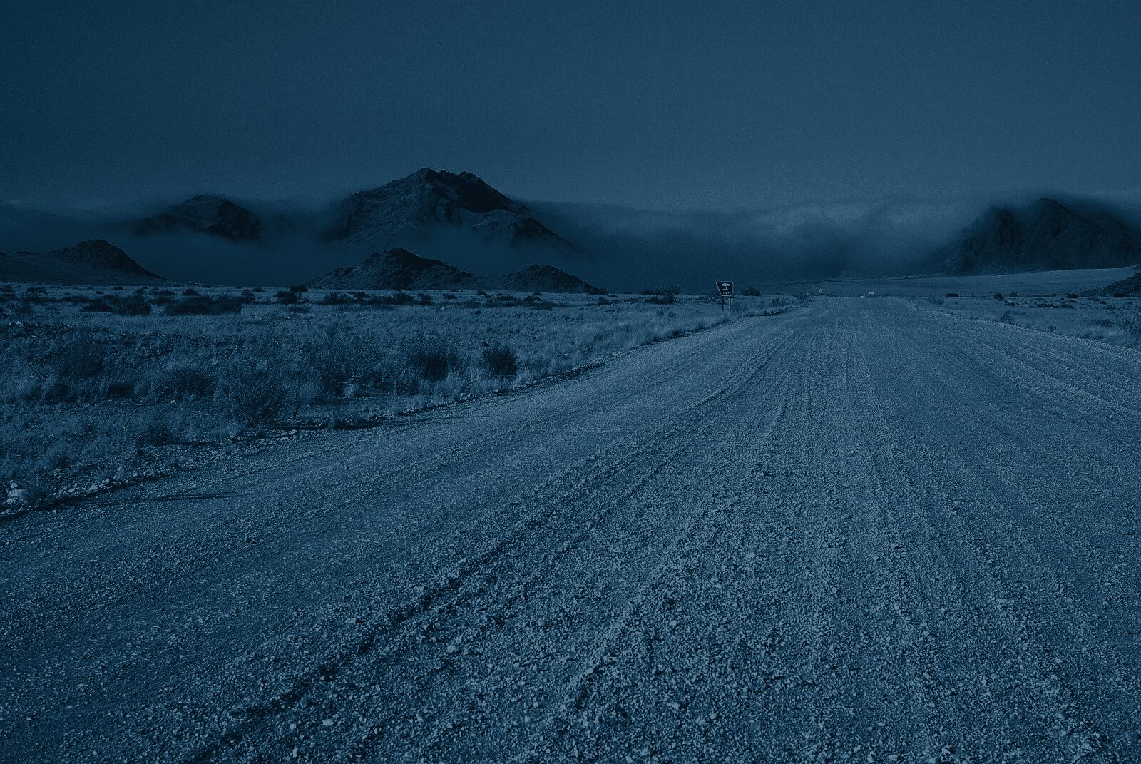 Gravel road winding through arid mountains in the Namib desert